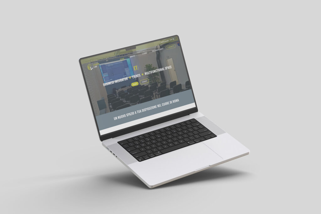 Un elegante laptop argentato mostra una pagina web che promuove lo sviluppo software di Sito Etiopialab, con testo e un'immagine di una sala conferenze sullo schermo. Il laptop è posizionato su uno sfondo grigio semplice.