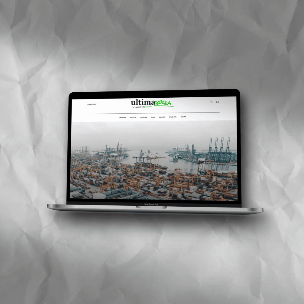 MacBook Pro che mostra la homepage del sito Ultimabozza, con sfondo di un porto industriale.